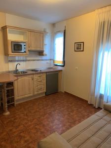 a kitchen with wooden cabinets and a sink and a window at Apartamento El Campanario in Zuheros