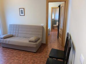 a living room with a couch and a bathroom at Apartamento El Campanario in Zuheros