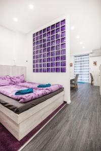 a bedroom with a large bed with purple sheets at Centre point Apartment in Budapest