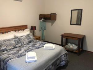ein Schlafzimmer mit einem Bett mit zwei Handtüchern darauf in der Unterkunft Hornbill Helipad 1 in Centurion