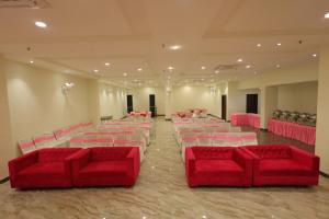 a large room with red chairs and pink tables at Hotel The Grand Tree in Agra