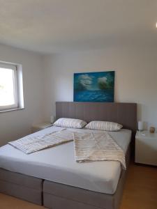 een slaapkamer met een groot bed en bij Apartments Familie Vujec in Skrbčići
