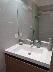 y baño con lavabo blanco y espejo. en Le Girond'Inn, en Libourne