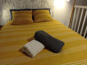 Una cama con dos toallas encima. en Le Girond'Inn, en Libourne