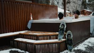un homme et une femme dans un bain à remous avec snowboard dans l'établissement Ouray Riverside Resort - Inn & Cabins, à Ouray