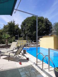 una piscina con 2 tumbonas junto a ella en Apartments Familie Vujec, en Skrbčići