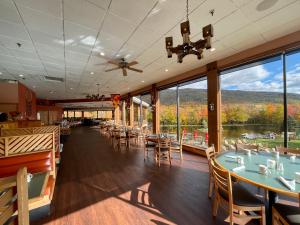 restauracja ze stołami i krzesłami oraz dużymi oknami w obiekcie Indian Head Resort w mieście Lincoln