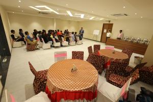 a group of people in a room with tables and chairs at The Grand Tree Hotel in Agra