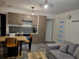 eine Küche und ein Wohnzimmer mit einem Tisch und einem Sofa in der Unterkunft Agréable maisonnette à proximité du centre-ville in Oyonnax