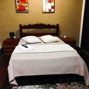 a bedroom with a bed with two towels on it at Pousada Maricá in Maricá