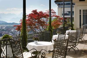 eine Reihe von Tischen und Stühlen auf einem Balkon mit Aussicht in der Unterkunft Château Gütsch in Luzern