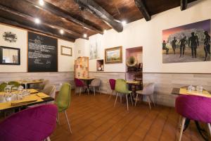 ein Restaurant mit lila und grünen Stühlen und Tischen in der Unterkunft Opera Suites - Il sentiero della felicità in Calcata