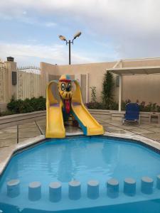 - une piscine avec un toboggan gonflable dans un complexe dans l'établissement Serenity Home Hurghada, à Hurghada