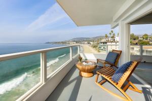 a balcony with two chairs and a view of the ocean at Pacific Edge Hotel on Laguna Beach in Laguna Beach