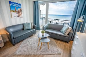 a living room with two couches and a view of the ocean at Studio 34 "Leuchtfeuer" mit Meerblick in Grömitz