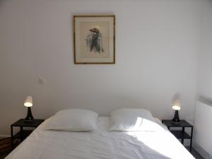 a bedroom with a white bed with two lamps at Apt. neuf à 50m du port - Parking privé, ascenseur in Saint-Valery-sur-Somme