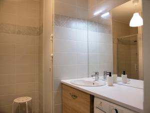 a bathroom with a sink and a mirror at Apt. neuf à 50m du port - Parking privé, ascenseur in Saint-Valery-sur-Somme +12 photos
