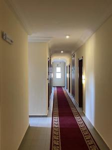 a long hallway with a red carpet in a building at LA ROCHELLE HOTEL in Yaoundé
