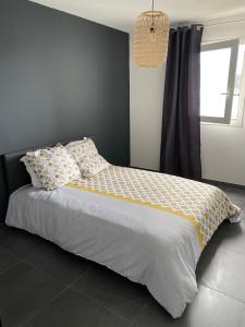 a bedroom with a large bed with pillows on it at ROMARINE in Sainte-Clotilde