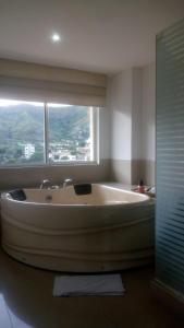 卡利的住宿－AW Hotel Chipichape Urban，带窗户的浴室设有大浴缸