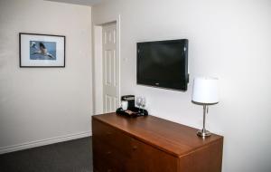 a room with a dresser with a television on a wall at Hotel Les Trois Soeurs in Perce
