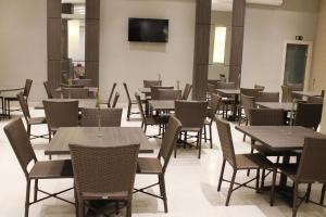 un comedor lleno de mesas y sillas en Flat 808 moderno e privilegiada localização no Centro, en Três Rios