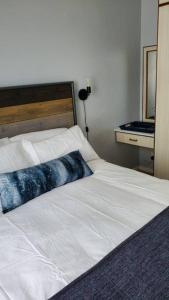 a bedroom with a white bed and a mirror at TinyApartment@Mosselbay - Entire 1 Bedroom Apartment Mossel Bay Central in Mossel Bay
