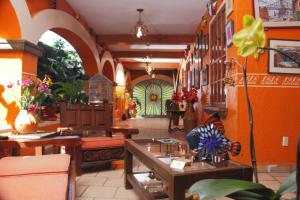 a restaurant with orange walls and tables and a colorful door at CasaGrande Posada Ejecutiva in Cuernavaca