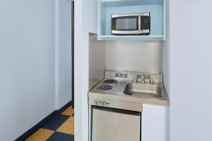 a kitchen with a microwave and a sink at Ewa Hotel Waikiki in Honolulu