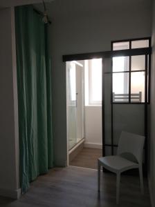 a room with a chair and a door with a window at T2 - 2 à 3 personnes - draps et serviettes en option in Lorette