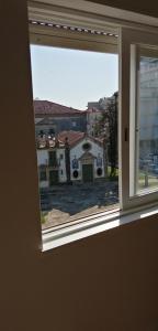 une fenêtre ouverte avec vue sur un bâtiment dans l'établissement Alex Point - Guest House, à Viana do Castelo