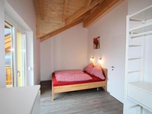 a small bedroom with a red bed in a room at Haus Seltschach in Arnoldstein