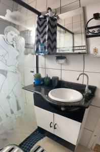 a bathroom with a sink and a mirror at Apto Top Boqueirão Praia Grande. in Praia Grande
