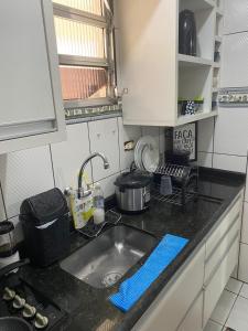a kitchen with a sink and a counter top at Apto Top Boqueirão Praia Grande. in Praia Grande