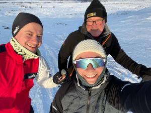 un grupo de tres personas de pie en la nieve en Torsetlia Cottages and Apartments en Uvdal
