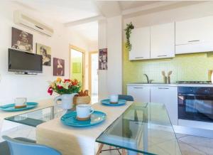 uma cozinha e sala de jantar com uma mesa de vidro e cadeiras em Punta Ovest a due passi del MARE em Marina di Montenero