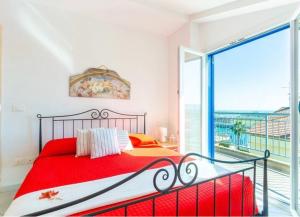 a bedroom with a red bed and a large window at Punta Ovest a due passi del MARE in Marina di Montenero