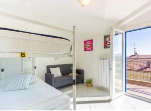 a bedroom with a bed and a couch and a balcony at Punta Ovest a due passi del MARE in Marina di Montenero