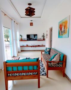 ein Wohnzimmer mit zwei Bänken und einer Couch in der Unterkunft Casa Doce Lar Caraíva in Caraíva