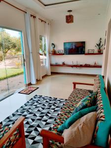 ein Wohnzimmer mit Sofa und Fernseher in der Unterkunft Casa Doce Lar Caraíva in Caraíva