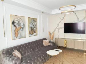 a living room with a couch and a flat screen tv at Selling Sunset Apartments in Timişoara