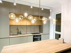 a kitchen with a chandelier above a wooden table at Selling Sunset Apartments in Timişoara