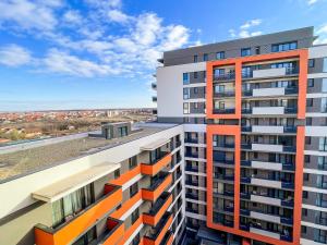 an apartment building with orange and white balconies at Selling Sunset Apartments in Timişoara