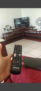 una persona con mando a distancia en una sala de estar en Residence Sonho Azul, en Salvador