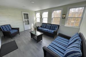 a living room with two couches and a table at Spacious, Sunny Lake House! Close to ski trails. in Windsor