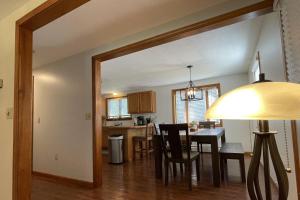a dining room and kitchen with a table and chairs at Spacious, Sunny Lake House! Close to ski trails. in Windsor