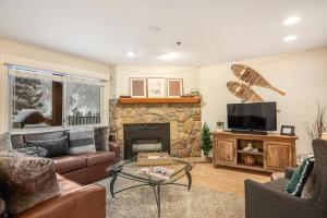 a living room with a fireplace and a tv at Vail Dreams in Vail