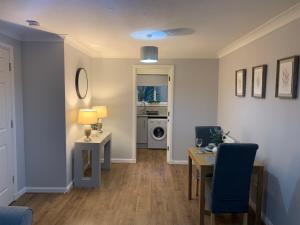 uma sala de estar com uma mesa e cadeiras azuis em Kinfirth Apartment em Ayr