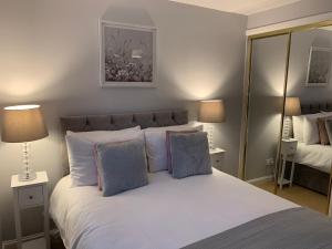 una camera da letto con un grande letto bianco con due lampade di Kinfirth Apartment ad Ayr