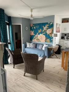 een woonkamer met een blauwe bank en stoelen bij Appartement F3 avec jolie vue in Le Barcarès